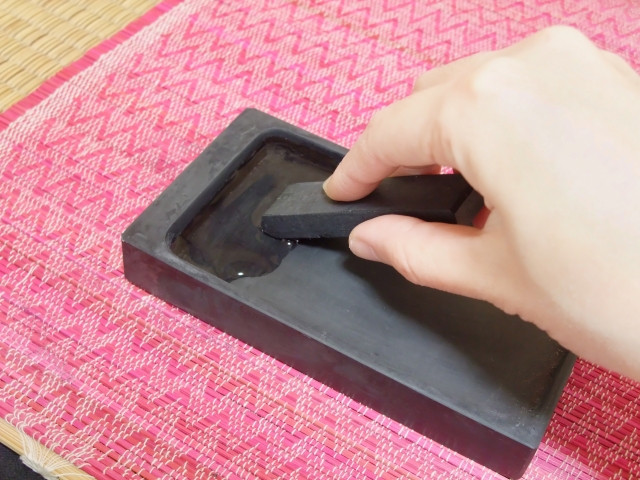 硯で固形の墨を磨っているところ