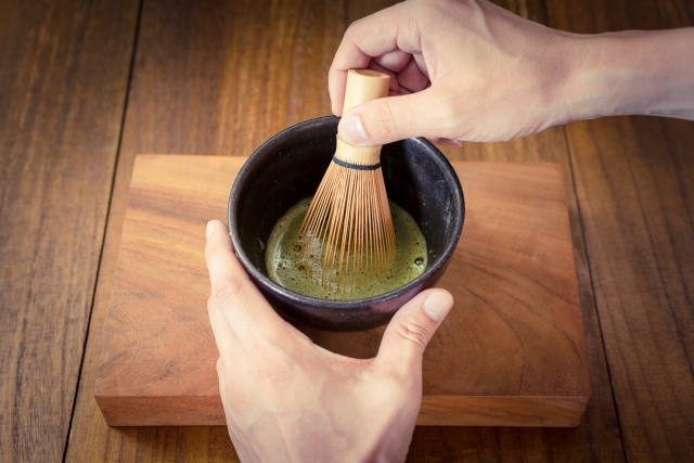 茶碗の抹茶を茶筅で点てている手元