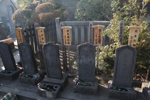 名前を書いた卒塔婆の前に並ぶ泉岳寺の赤穂義士の墓石