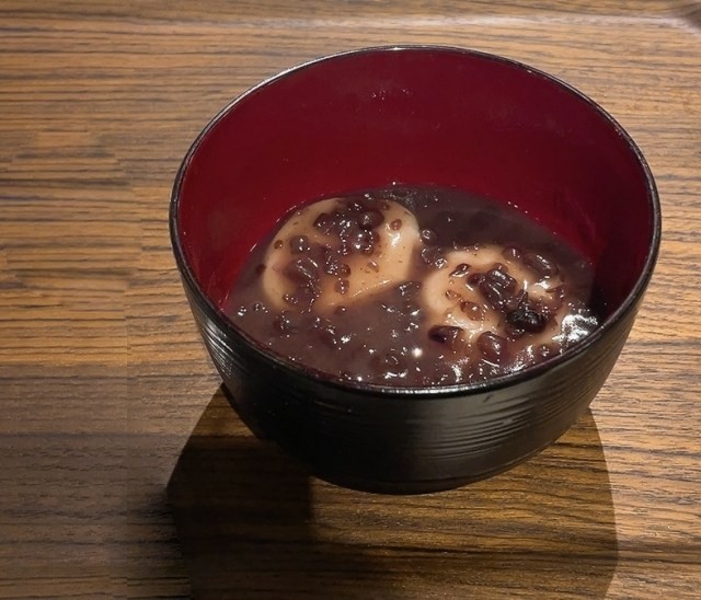 黒い椀に盛られた小豆雑煮。小豆の間から丸餅が見える