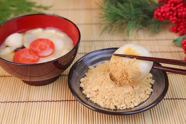 白味噌仕立てのお雑煮と、丸餅をきなこにつけて箸で持ち上げたところ